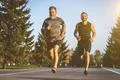 The father and a son running on a park road Photo