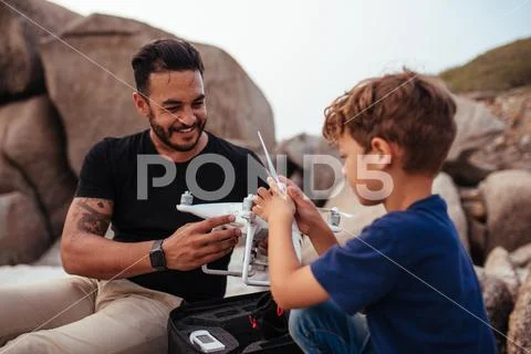 Father and son set up drone at the beach Stock Photos