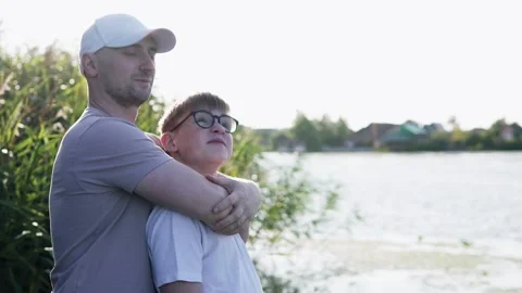 Father and son sharing a warm hug by the water on Father’s Day. Stock Footage 321835766