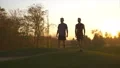 The father and a son showing muscles on the sunset background. slow motion 4k or 4k+ Resolution