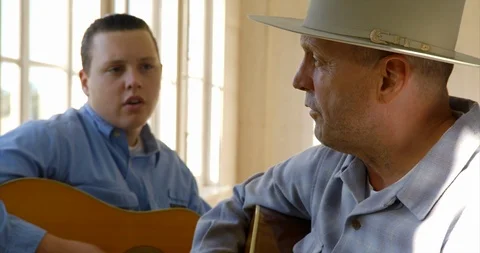Father and son sing and play guitar together. Stockbeeldmateriaal 88375439