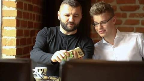 Father and son sitting in the cafe and doing selfies on smartphone Stock Footage 80424418