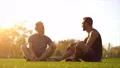 The father and a son sitting on the grass and talking. slow motion 4k or 4k+ Resolution