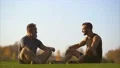 The father and a son sitting on the grass and talking. slow motion 4k or 4k+ Resolution