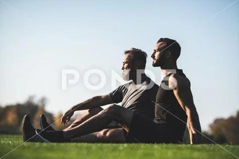 The father and a son sitting on the grass Stock Photos