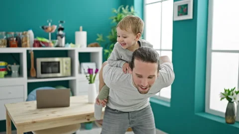 Father and son smiling confident dancing together at dinning room Stock Footage 237293530