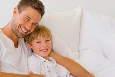 Father and son on sofa Stock Photos