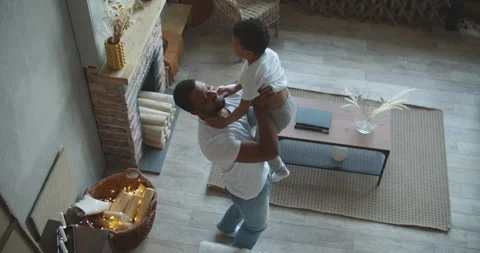 Father and son spending time together. Dad is holding his son at home in living Stock Footage 151655076
