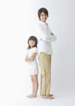 Father and son standing back to back Stock Photos