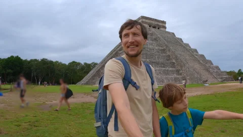 Father and son standing in front of Kukulkan pyramid in Chichen Itza, Mexico Stock Footage 338350350
