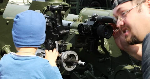Father and son study the optics of artillery guns Stock Footage 101158026
