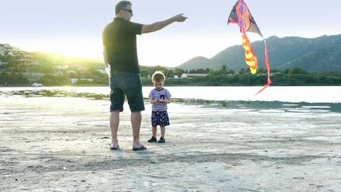 Father and son at sunset launch a kite into the sky, slow motion HD Stock Footage 125333851