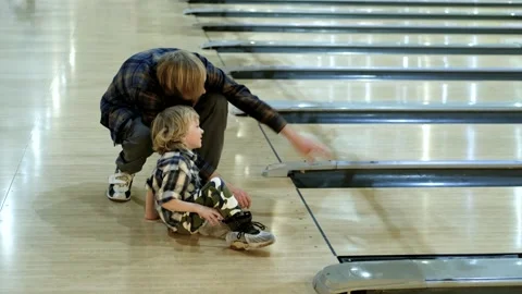 Father and son throwing a ball on a bowling alley 動画素材 305141677