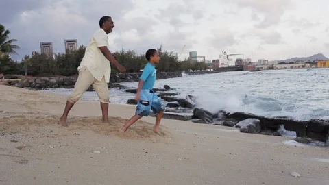 Father and son throwing rocks on a beach. 스톡 동영상 88371833