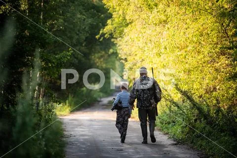Father and son together hunting together. Walking the road in a forest. Stock Photos