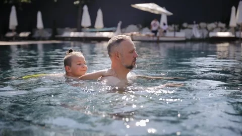 Father and son together in pool. Dad teaches his son to swim Stock Footage 267284713