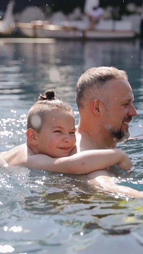 Father and son together in pool. Dad teaches his son to swim Stock Footage 267762056