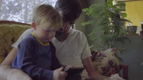 Father and son use mobile phone Stock Footage 64406939