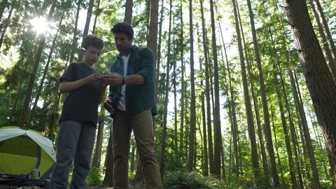 Father and son using a compass in the woods Stock-Footage 88012516