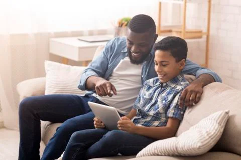 Father and son using digital tablet at home, checking new application Foto stock