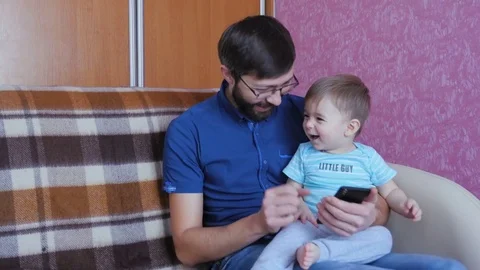 Father And Son Using Smart Phone Together Stock Footage 71974781