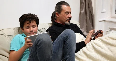 Father and son using smartphone and digital tablet computer Video stock 102533908