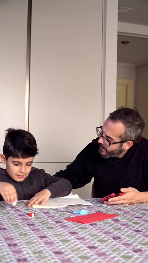 Father and son using smartphone to write at home Stock Footage 345253913