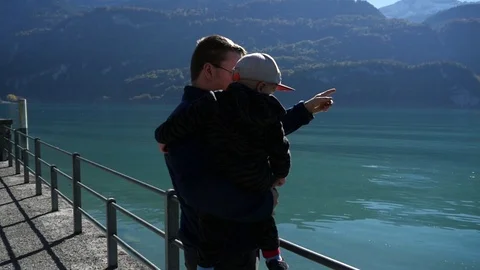 Father and son, view a man showing his kid, the view of a turquoise lake, on  Stock Footage 86568560