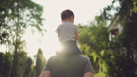 Father and son walking in city at sunset Stock Footage
