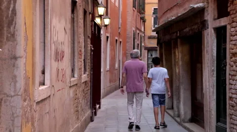 Father and Son Walking Down a Street in Venice, Italy Stock Footage 65964739