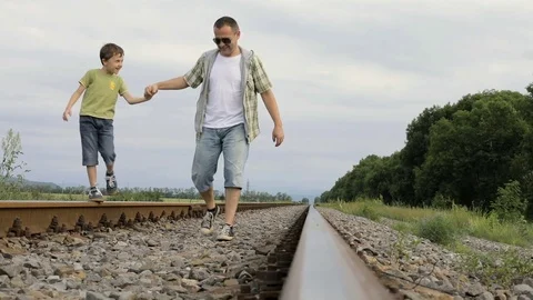 Father and son walking on the railway at the day time. Stock Footage