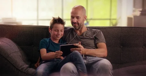 Father and son watching something on tablet Stock Footage 78664792
