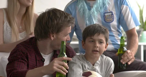 Father and son watching televised soccer match at home, slow motion Stock Footage 87465756