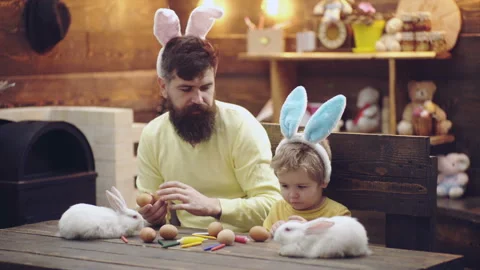 Father and son wearing easter bunny ears. Funny faces. Happy family painting Stock Footage 142956508