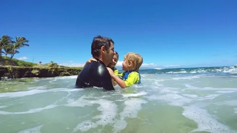 Father and sons playing at the beach Stock Footage 77633879
