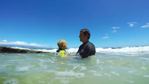 Father and sons playing at the beach Stock Footage 77633924