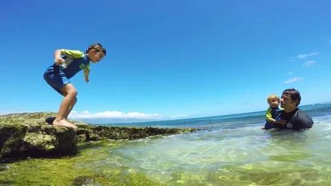 Father and sons playing at the beach Stock Footage 77633998