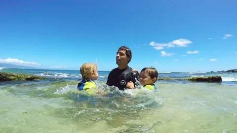 Father and sons playing at the beach Stock Footage 77634038