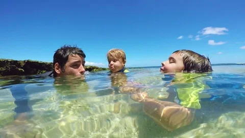 Father and sons playing at the beach Stock Footage 77634087