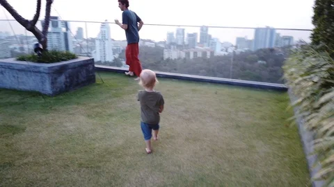 Father and two-year-old child play catch-up on the viewing platform. family happ Stock Footage 104950094