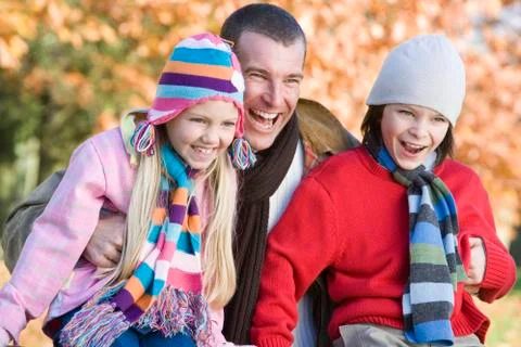 Father and two young children outdoors in park laughing (selective focus) Stock Photos