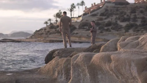 A father and a young son fish together on the shore. Spain, Alicante Stock Footage 322173760