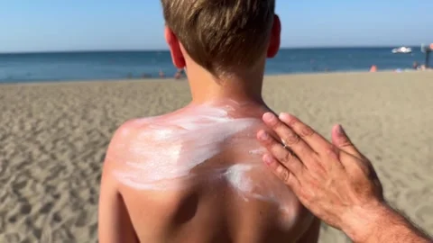 Father applying sunblock lotion on sons skin for sun protection little boy Stock Footage 285045802