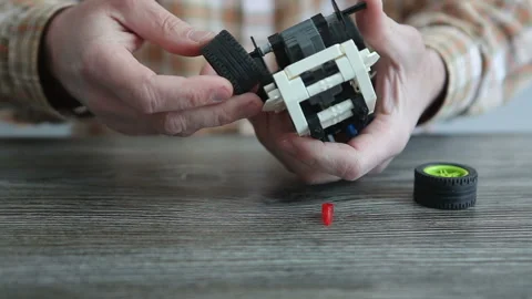 Father assembles machine constructor from parts for his son.repairs children car Video stock 240135637