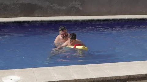 Father assisting disabled son with cerebral palsy during hydrotherapy Video stock 342766341