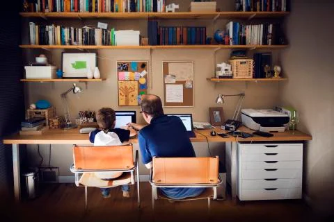 Father assisting son in using laptop computer at home Stock Photos