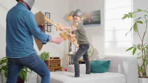 Father being defeated by his son in Playing knight's swordfight Stock Footage 170444164