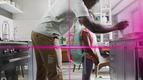 Father bending adjusting kid school backpack in kitchen, reaching green apple Stock Footage 333632114