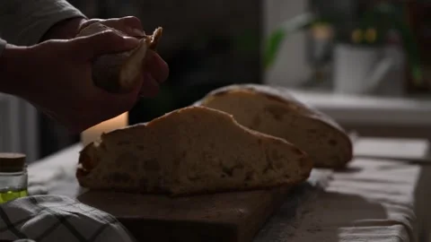 Father breaks bread piece and offers it to daughter, hands and bread close-up. Видео 309259453