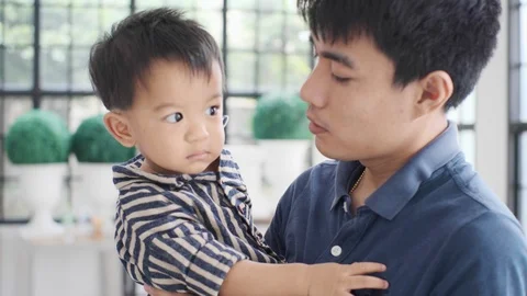 Father carry and playing with baby boy in modern living home Stock Footage 121860153